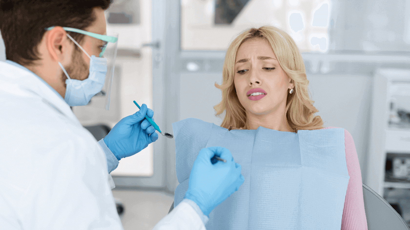 Patientin mit angsterfülltem Blick auf Zahnarztstuhl
