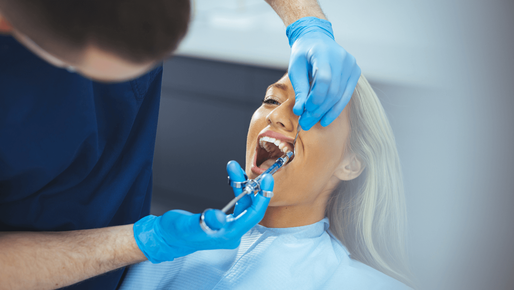 Patientin bekommt eine Spritze in den Oberkiefer beim Zahnarzt